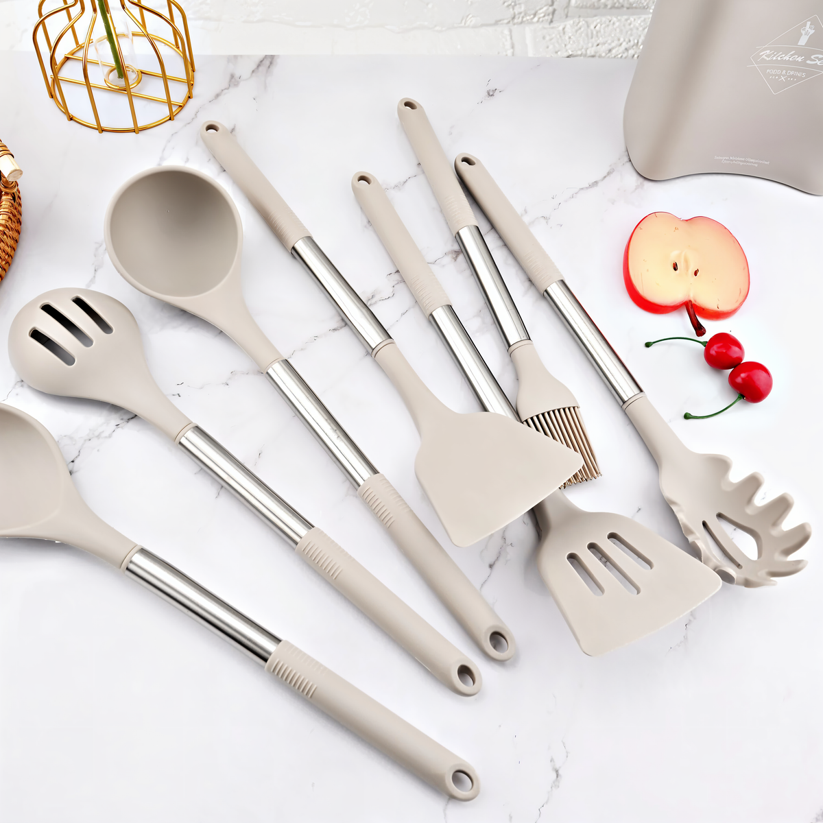 Küchenutensilien-Set aus Silikon und Edelstahl, grau, auf Marmorhintergrund.