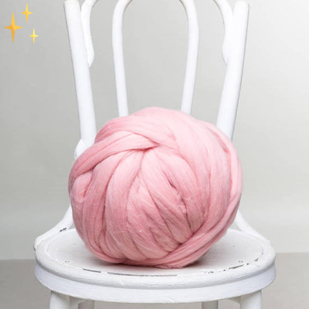 Rosa Merinowolle auf weißem Stuhl, ideal für Stricken und Häkeln, weiche Textur.